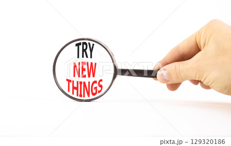 Try new things symbol. Concept words Try new things in beautiful magnifying glass. Beautiful white background. Businessman hand. Business motivational lifestyle try new things concept. Copy space. Try new things symbol. Concept words Try new things in beautiful magnifying glass. Beautiful white background. Businessman hand. Business motivational lifestyle try new things concept. Copy space. 129320186