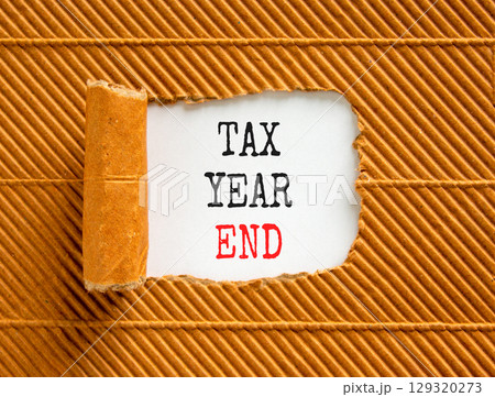 Tax year end symbol. Concept words Tax year end on beautiful white paper. Beautiful brown table brown background. Business tax year end concept. Copy space. Tax year end symbol. Concept words Tax year end on beautiful white paper. Beautiful brown table brown background. Business tax year end concept. Copy space. 129320273