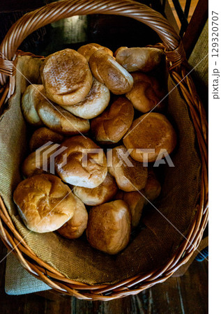 Basket full of bread is sitting on a table Basket full of bread is sitting on a table 129320707