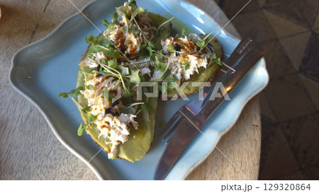 Healthy avocado toast with sprouts and spices on a blue plate. Healthy breakfast Healthy avocado toast with sprouts and spices on a blue plate. Healthy breakfast 129320864