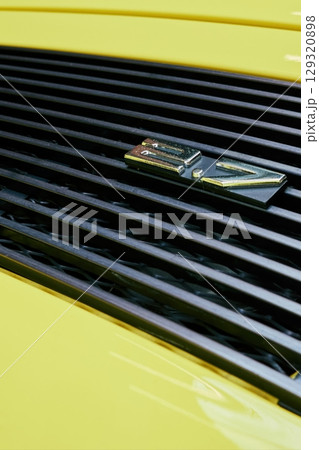 Yellow car with a black grill and a silver numbers 2.7 on it. Phone wallpapers. Vertical background. 129320898