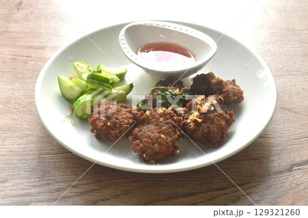 deep fried salty chop pork ball with garlic dipping sweet chili sauce and slice cucumber on plate 129321260