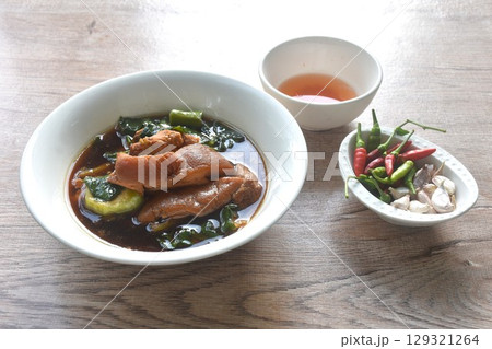 braised slice pork leg stew black Chinese herb soup and kale dipping mixed spicy sour chili sauce on plate eat couple fresh garlic braised slice pork leg stew black Chinese herb soup and kale dipping mixed spicy sour chili sauce on plate eat couple fresh garlic 129321264