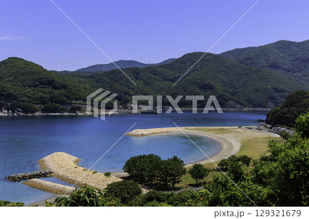 澄んだ青い海と緑の山が広がるムーンビーチ井野浦の絶景風景 澄んだ青い海と緑の山が広がるムーンビーチ井野浦の絶景風景 129321679