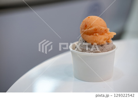 A cup of Gelato, Banana choc chip and tomato Ice-cream on the table with blur background. 129322542