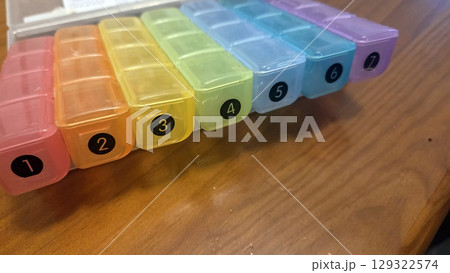 Weekly pill organizer with colorful seven-day compartments for medication management 129322574