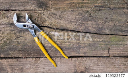 Plumber's wrench on rustic wooden surface for construction and repair concepts. Pipe wrench, Swedish wrench. Horizontal banner. Copy space Plumber's wrench on rustic wooden surface for construction and repair concepts. Pipe wrench, Swedish wrench. Horizontal banner. Copy space 129322577