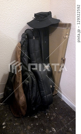 Collection of musical instrument cases in corner for storage or travel 129322592