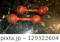 Vintage red dumbbells on dark marble floor for fitness and gym decor. Horizontal banner. Copy space. Healthy lifestyle 129322604