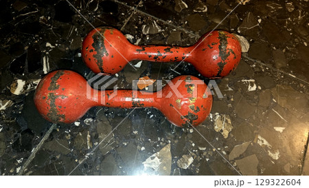 Vintage red dumbbells on dark marble floor for fitness and gym decor. Horizontal banner. Copy space. Healthy lifestyle 129322604