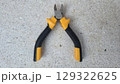 Essential hand tool for cutting wires and cables with ergonomic grip on stone surface. Wire cutters or diagonal cutting pliers 129322625