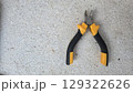 Durable industrial tool: diagonal pliers on concrete surface for construction and diy projects. Horizontal banner. Copy space. Wire cutters or diagonal cutting pliers 129322626