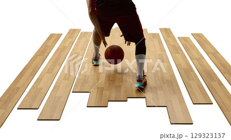 Close-up view of basketball player mid-dribble on wooden flooring with focused movement Close-up view of basketball player mid-dribble on wooden flooring with focused movement 129323137