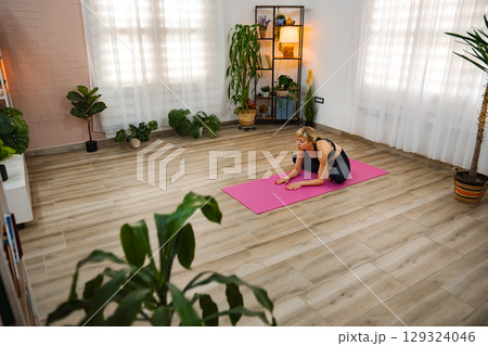 Yoga practice in a serene indoor space filled with plants 129324046