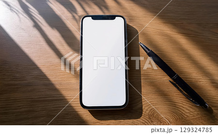 sleek smartphone with blank screen elegantly displayed minimalist desk, accompanied by pen, creates soft and modern atmosphere 129324785