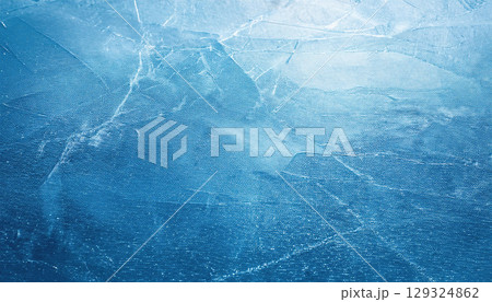 Textured ice surface with natural scratches showcasing cool winter palette 129324862