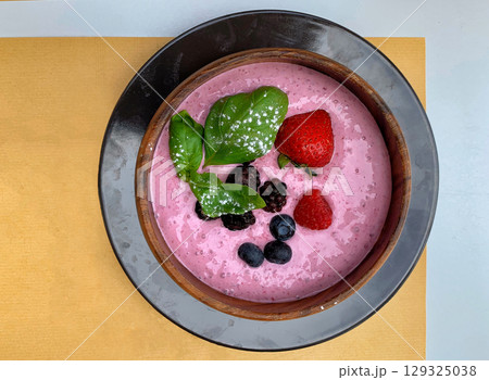Healthy Berry Smoothie Bowl with Fresh Fruits and Basil Leaves 129325038