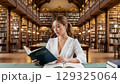 伝統的な図書館で読書する若い女性 129325064