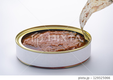 Opening a can of meat with a gold cap and a white background and hard to open. Opening a can of meat with a gold cap and a white background and hard to open. 129325066