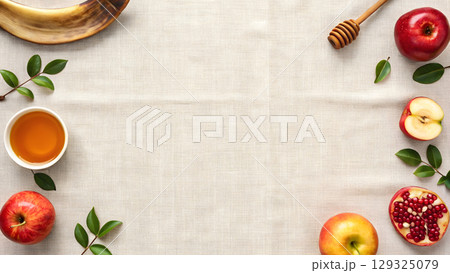 Fresh apples and honey arranged on a table with green leaves, Jewish holiday items 129325079