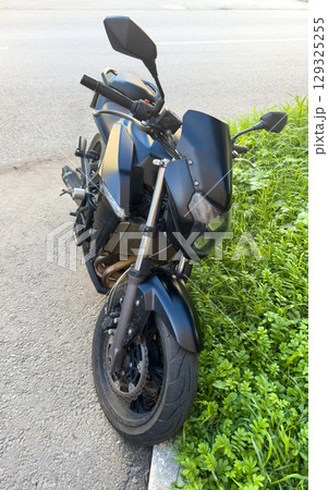 Powerful black motorcycle by the road on a sunny day Powerful black motorcycle by the road on a sunny day 129325255