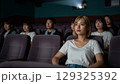 映画館で映画を鑑賞する若い女性 129325392