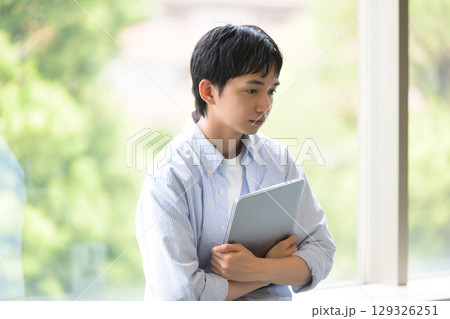 うつむき気味の男子学生の思案 うつむき気味の男子学生の思案 129326251