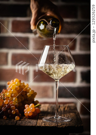 Pouring white wine 129326259