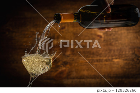 White sparkling wine being poured into a glass 129326260