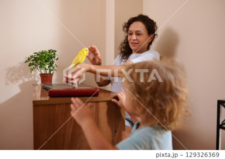 Mother and Child Bonding While Playing with a Yellow Pet Bird at Home Mother and Child Bonding While Playing with a Yellow Pet Bird at Home 129326369