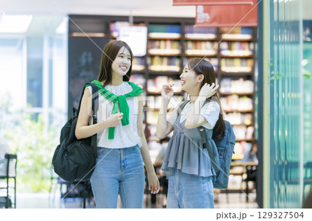 友達と大学構内の階段を上る女子大生 129327504