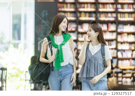 友達と大学構内の階段を上る女子大生 129327517