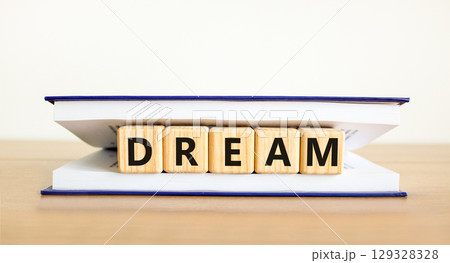 Dream symbol. Concept word Dream on beautiful wooden blocks in book. Beautiful wooden table white background. Business lifestyle dream concept. Copy space. 129328328