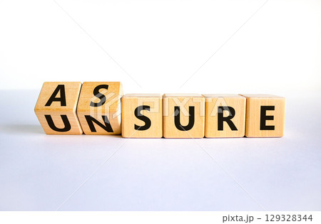 Assure or unsure symbol. Turned wooden cubes and changed the concept word unsure to assure. Beautiful white table, white background, copy space. Business and assure or unsure concept. Assure or unsure symbol. Turned wooden cubes and changed the concept word unsure to assure. Beautiful white table, white background, copy space. Business and assure or unsure concept. 129328344