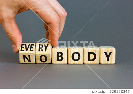 Everybody vs nobody symbol. Concept words Everybody and Nobody on wooden cubes. Beautiful grey table grey background. Businessman hand. Business and everybody vs nobody concept. Copy space. 129328347