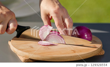chef cuts fresh red onion  129328554