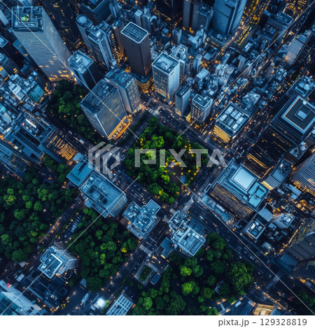 Aerial view of a city at dusk, with illuminated streets and green parks amid tall buildings. Concept of urban planning and cityscapes. 129328819