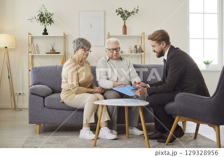 Senior Couple Negotiating With Consultant At Home Senior Couple Negotiating With Consultant At Home 129328956