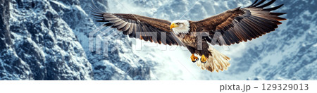 An eagle soars through the sky with snow-covered mountains in the background. Concept of freedom and nature's majesty. 129329013
