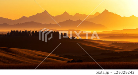 Rolling hills and silhouetted mountains bask in a golden sunset. Concept of serene nature and tranquility. For landscape photo collection. Rolling hills and silhouetted mountains bask in a golden sunset. Concept of serene nature and tranquility. For landscape photo collection. 129329242