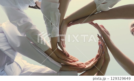 Friends make hand shapes against a blue sky background Friends make hand shapes against a blue sky background 129329649