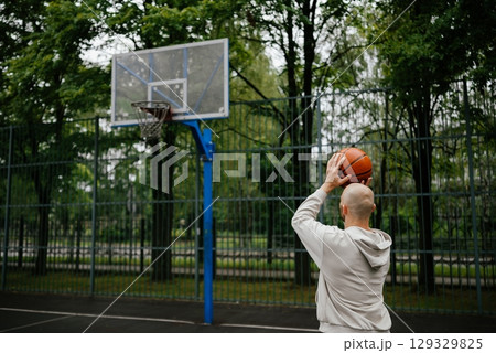 Man Shooting Basketball on Outdoor Court 129329825