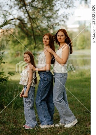 Three Generations of Women Standing Outdoors Smiling Three Generations of Women Standing Outdoors Smiling 129329920