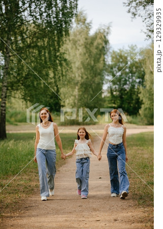 Family Stroll in Nature Park Holding Hands 129329935