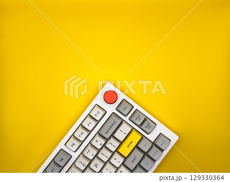 Workspace desk with it keyboard, red and yellow buttons, with yellow background. Flat lay. Top view, copy space. Workspace desk with it keyboard, red and yellow buttons, with yellow background. Flat lay. Top view, copy space. 129330364