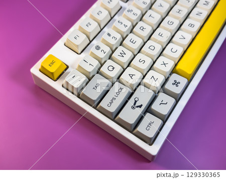 White and yellow keyboard on a purple background 129330365