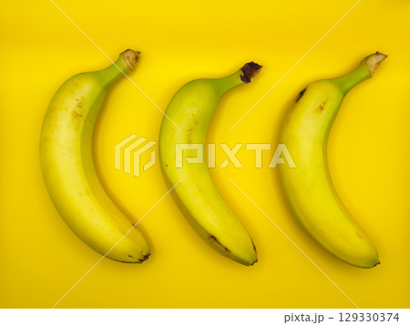 Colorful fruit pattern of fresh yellow bananas on yellow background. From top view 129330374