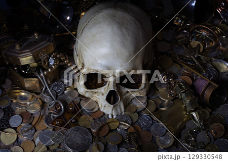 Skull among treasure coins and jewellery. 129330548