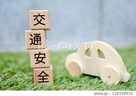 交通安全の文字ブロックと木製自動車の芝生背景イメージ 129330918