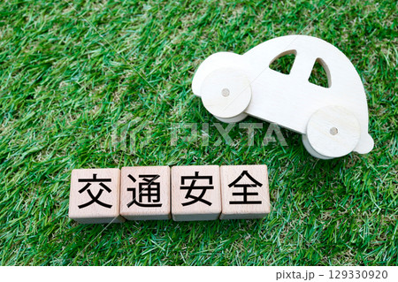 交通安全の文字ブロックと木製自動車の芝生背景イメージ 129330920
